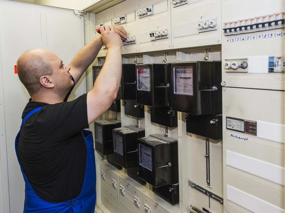 Elektroinstallation und Wartung von Schaltanlagen Elektriker bei Wartungsarbeiten an einer elektrischen Schalt- und Verteileranlage
